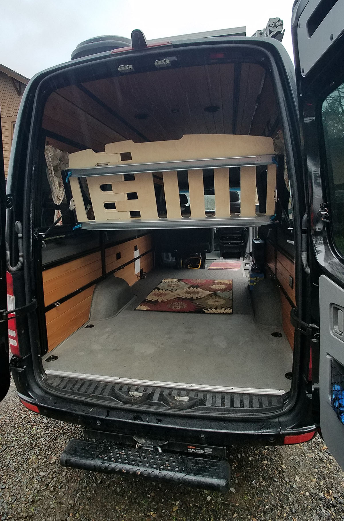 Adjustable bed, tilts to create easier access in the back of our converted Sprinter van